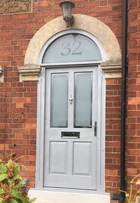 Traditional four panelled timber front door with glazed arched top light