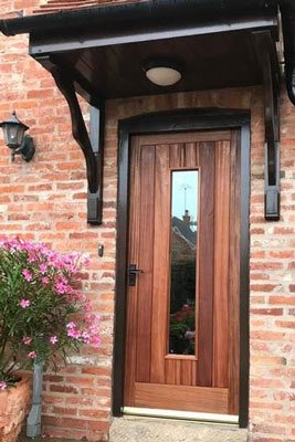 Timber door with single glazed panel and small porch cover